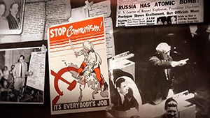 Black and white images from the cold war with a STOP communism poster in red