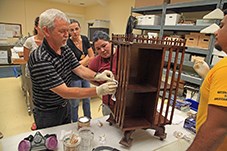 Conservation Training A man shows four other people how to repair a wooden table