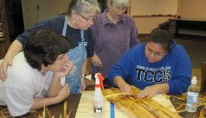 Four women work together on a craft project.