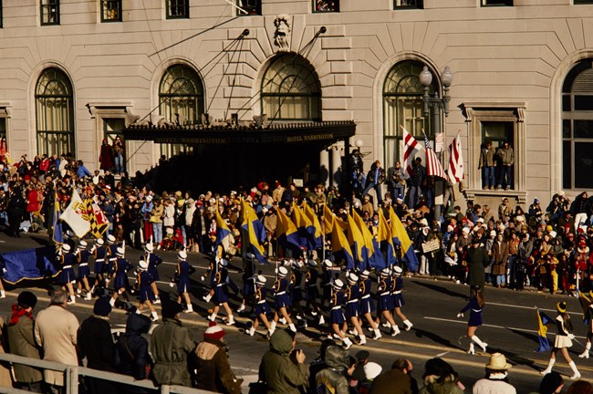Color guard during President Jimmy Carter's inaugural parade A color guard walks carrying flags down a city street lined with observers