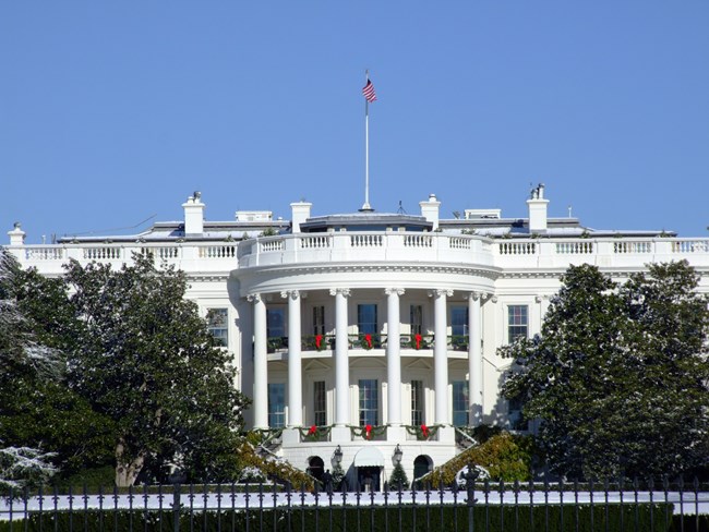 South view of the White House South view of the White House framed by trees.