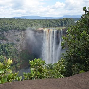 In the distance, a large waterfall can been seen emptying into a valley in Kaieteur National Park, Guyana. In the distance, a large waterfall can been seen emptying into a valley in Kaieteur National Park, Guyana.