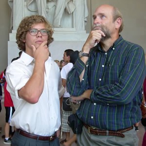 Two male visitors to the Lincoln Memorial ponder the memorial. Two male visitors to the Lincoln Memorial ponder the memorial.