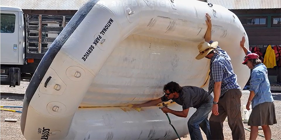 invasive three employees clean off an inflatable boat