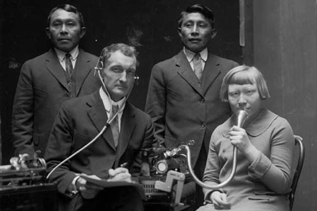 J. P. Harrington posing with three Cuna (Tule) while making dictaphone recordings of Cuna language and songs, 1924, photograph by DeLancey Gill, National Anthropological Archives, Smithsonian Institution.