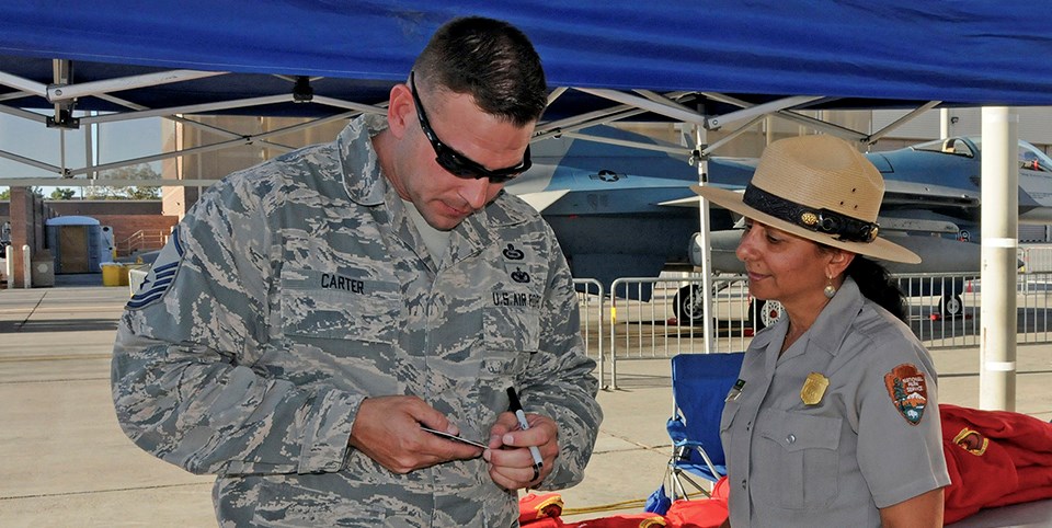 Ranger assists man in fatigues with information. Ranger assists man in fatigues with information.
