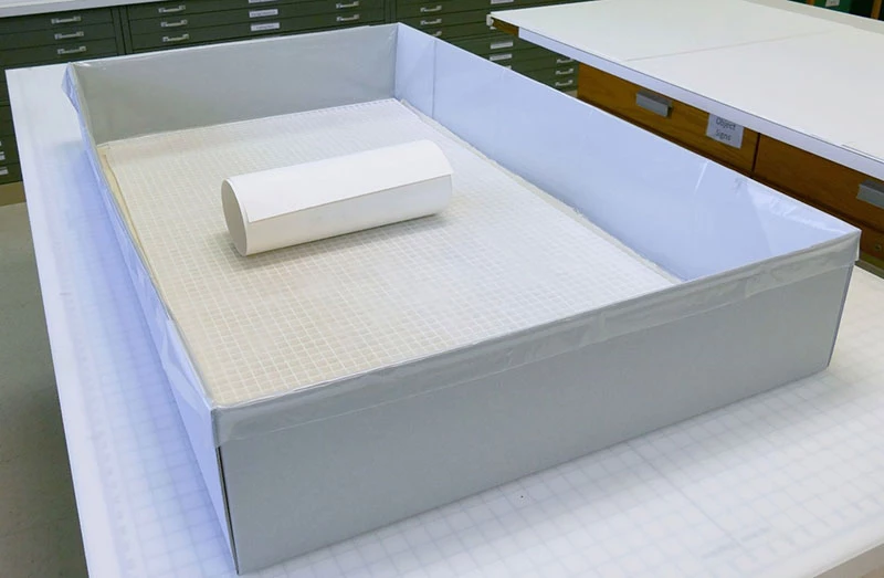 Rolled paper on non-woven spun polyester fabric, “egg crate”, and dampened muslin within the plastic lined container.