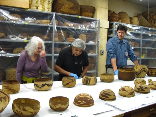 Two members of the Karuk Tribe of California and the museum’s NAGPRA Coordinator viewing baskets and their associated information during a NAGPRA grant-funded visit.