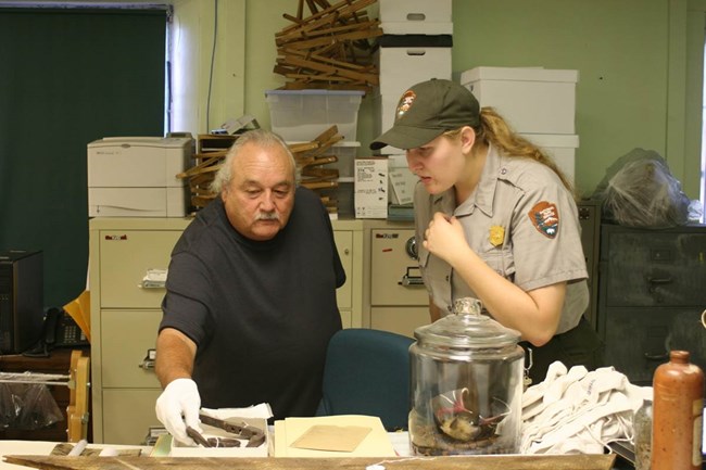 Representatives from a tribe and federal agency consulting on possible summary items. Representatives from a tribe and federal agency consulting on possible summary items.