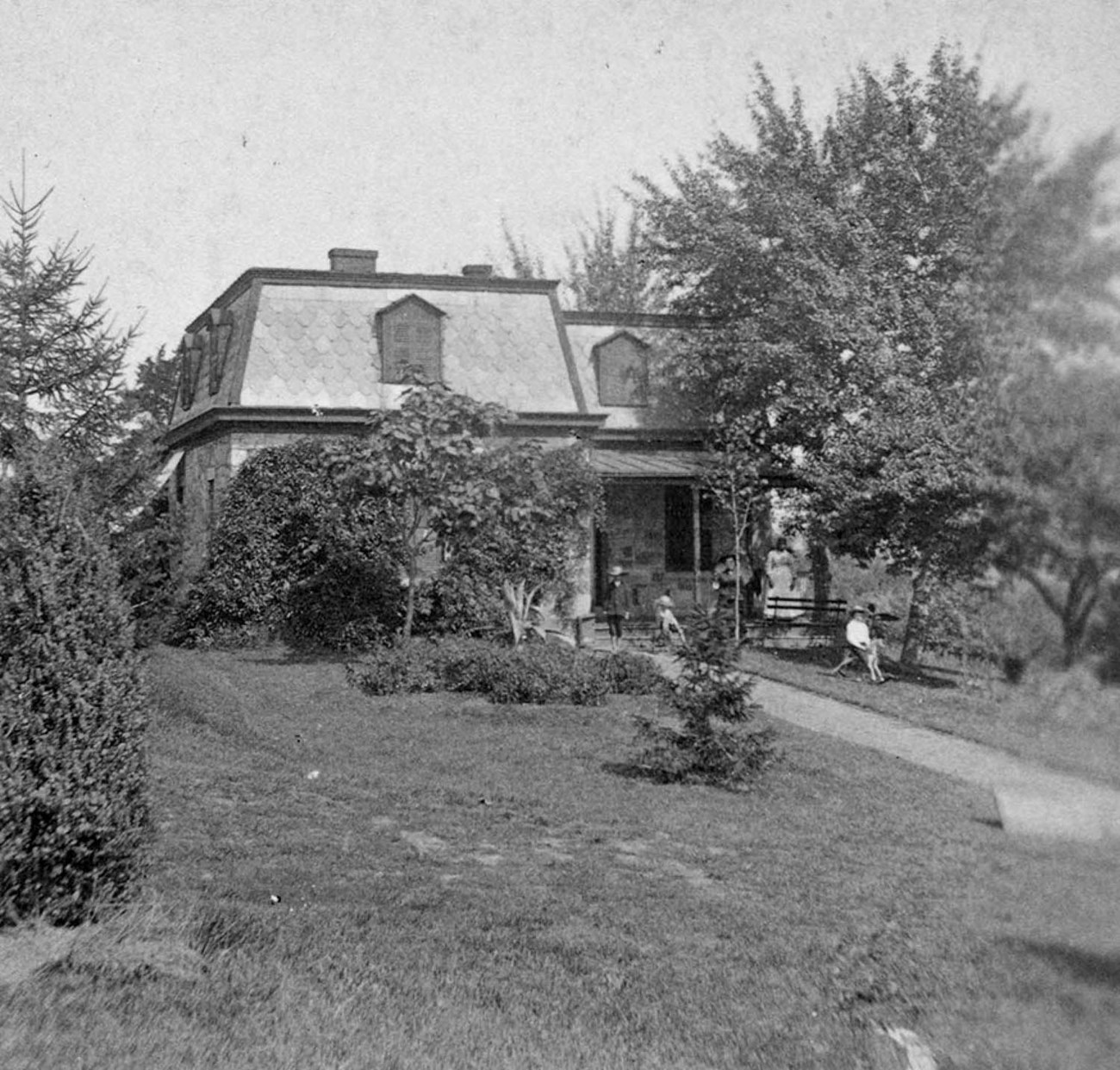 FRSP lodge in early 1880s A two-story lodge with a mansard roof is surrounded by trees and shrubs and a short lawn.