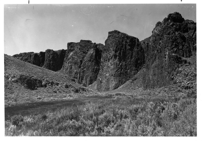 canyon on horizon behind grassy field