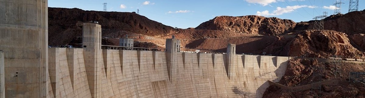 Close-up view of Hoover Dam, which straddles the Arizona and Nevada borders on the Colorado River. Color photo emphasizing dramatic sweep of towering reinforced concrete dam