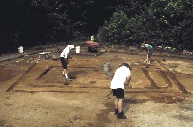three archeologists at work on site