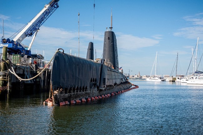 USS Clamagore submarine buoyed partially out of the water exposing structural hull damage due to corrosion.