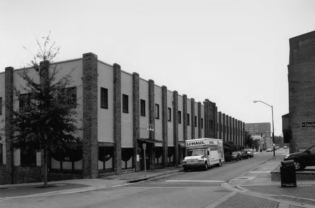 Image of multistory buildings, roads, traffic light, and vehicles.