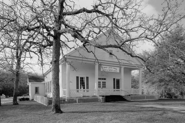 The church is a single-story, rectangular wood-framed meetinghouse that is five bays long and three bays wide with a tetrastyle portico across the front gable (Photographs 3, 10). The main building is clad in weatherboard siding.