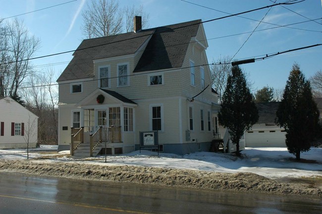 The one-and-a-half-story, cross gable house on street