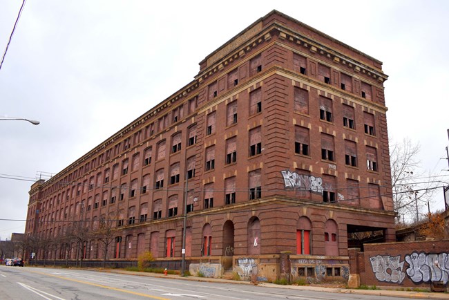 5-story red brick building fronting an avenue