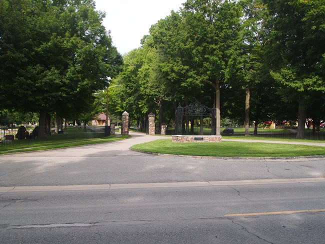 Entrance to Highland Cemetery showing metal entrygate and stone pillars