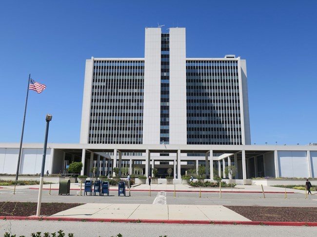 A monumental complex is composed of a soaring 17-story office tower connected to two single story wings by a colonnaded pavilion and entry plaza
