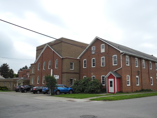 2 and one-half story brick builiding with gal bel roof