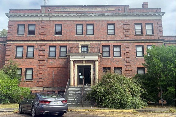 Entrance to large brick building with stairs leading to front door.