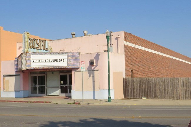100007474 Royal Theater photo front A building with a large sign and double entrances.