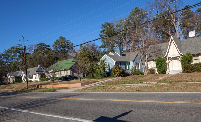 Streetview with 4 single houses with yards