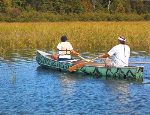 two men in a canoe on a stream