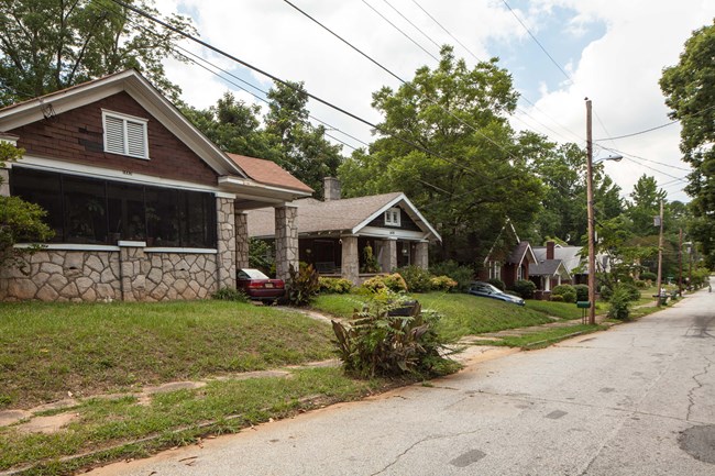 Residential street with detached houses setback about 30 feet from street.