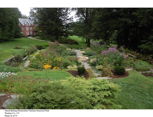 Garden with water fountain and house in background