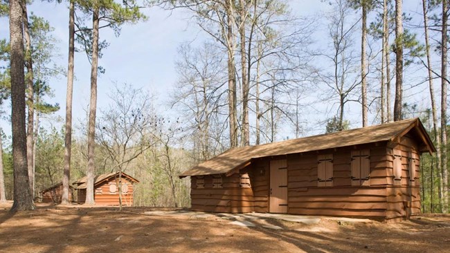 Hard Labor Creek State Park, Morgan and Walton, Georgia Image is focused on a small, wood cabin with two wooden cabins in the behind it.