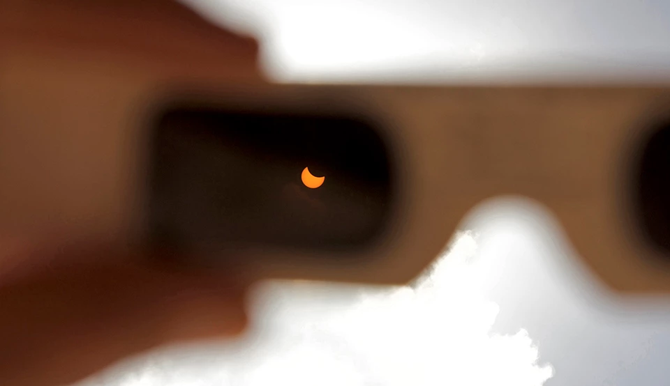 Glasses Eclipse in focus in the lens of eclipse glasses