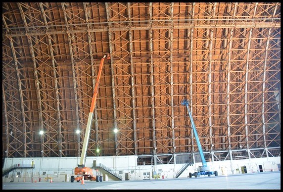 Blimp Hanger Two lifts extended high into the ceiling of semicircular wooden roof supports forming an intricate geometric design.