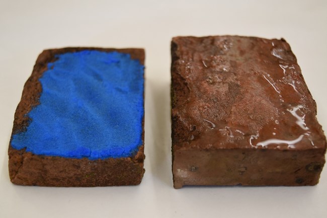 Two rectangular brick samples next to each other. The brick on the left has blue on it. Two rectangular brick samples next to each other. The brick on the left has blue on it.