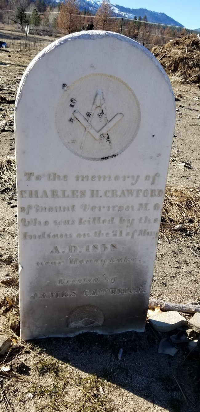 White headstone stained by soot from a wildfire A white headstone is stained dark grey by soot at the bottom from a wildfire