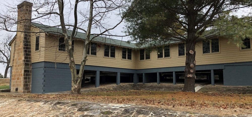 Black Officers’ Club Rear elevation of Black Officers’ Club, with stone chimney and retaining wall built by German POWs, after rehabilitation, 2018.