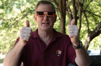Eclipse101 A man wears eclipse sunglasses and gives the thumbs up sign