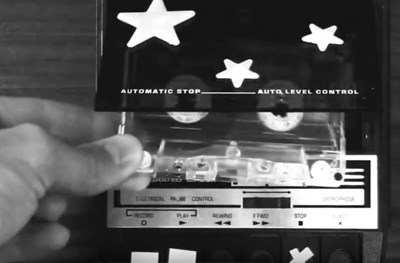 UnSung_videogallery_thumb Close up of a hand putting a tape cassette into a recorder
