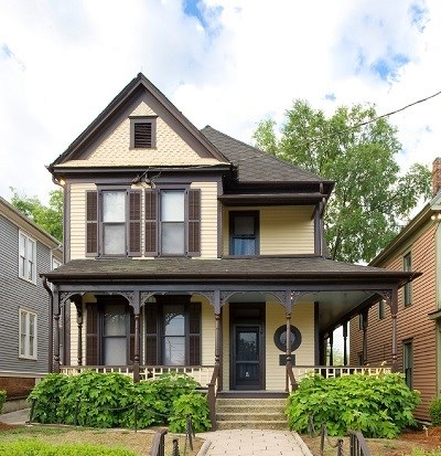 Two-story yellow house with brown trim