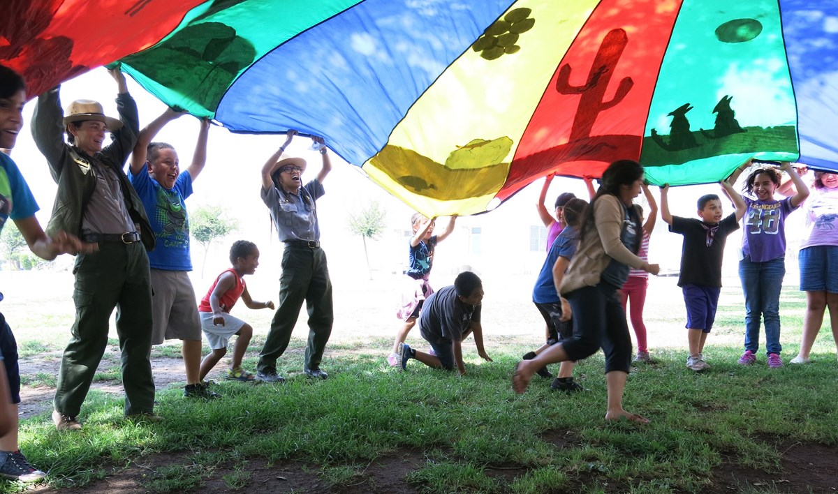 Rangers and kids playing with a colorful parachute Rangers and kids playing with a colorful parachute