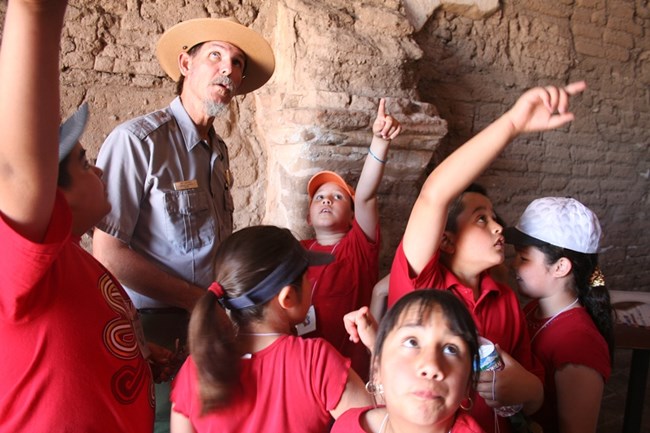 Ranger and students exploring the inside of the mission church at Tumacacori National Historical Park Ranger and students exploring the inside of the mission church