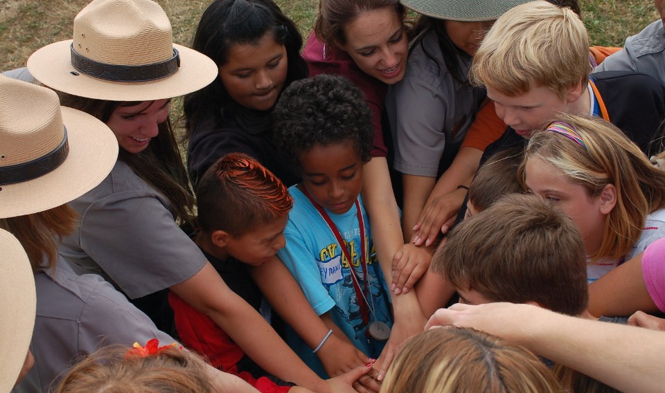 Group of park rangers and kids join hands