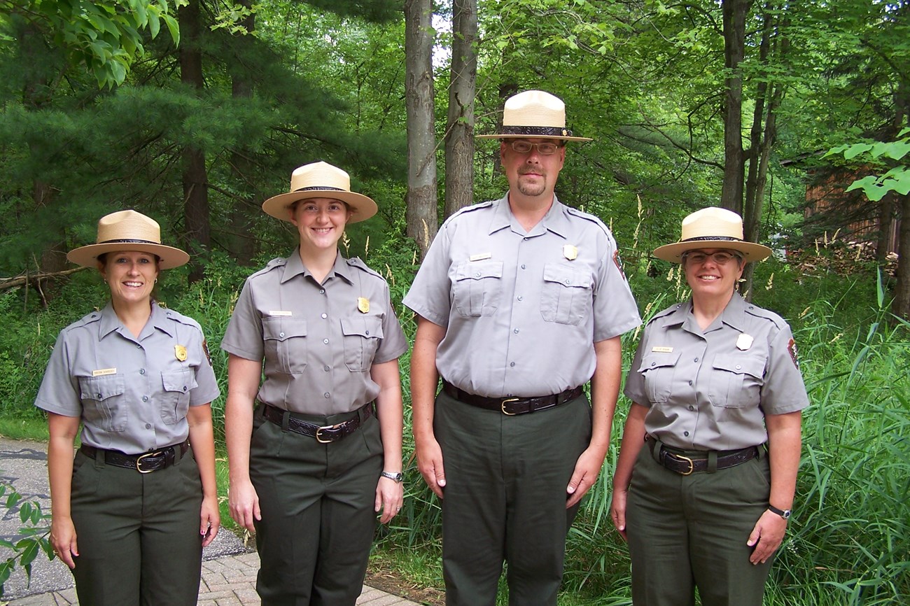 four rangers standing in a forest