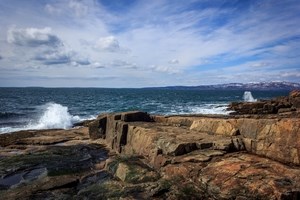 ocean waves crashing against a rocky cliff