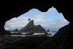 Hole in the wall view of ocean looking through a cave
