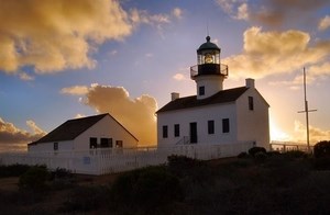 lighthouse on cliff with sunset in background