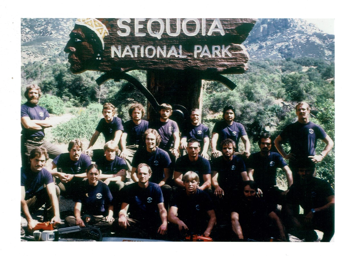 A group of people pose in front of a sign that says "Sequoia National Park"