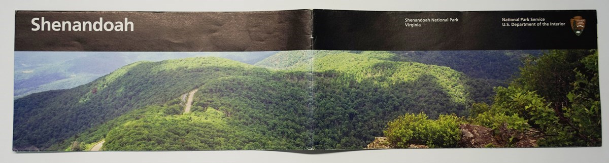 An image of tree-covered, rolling hills on the cover of a Shenandoah National Park brochure