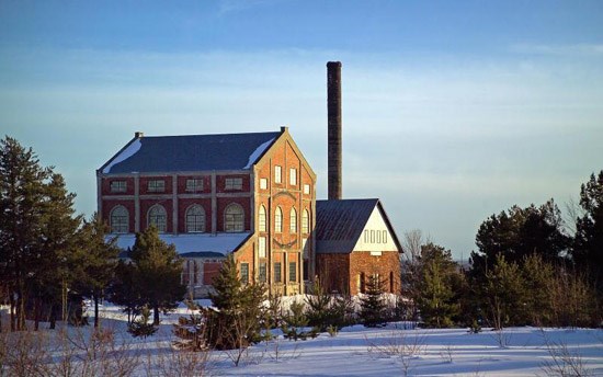 Keweenaw The red brick Quincy Mine Hoist House with tall smoke stack in a snowy landscape
